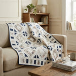 Handmade lap quilt shown draped over a sofa in a neutral living room