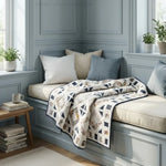 Handmade lap quilt shown on a window seat in a light blue room