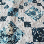 Close up of Weathered Blue lap quilt showing fabric detail and quilt stitching detail.