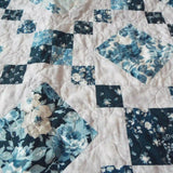 Close up of Weathered Blue lap quilt showing fabric detail and quilt stitching detail.