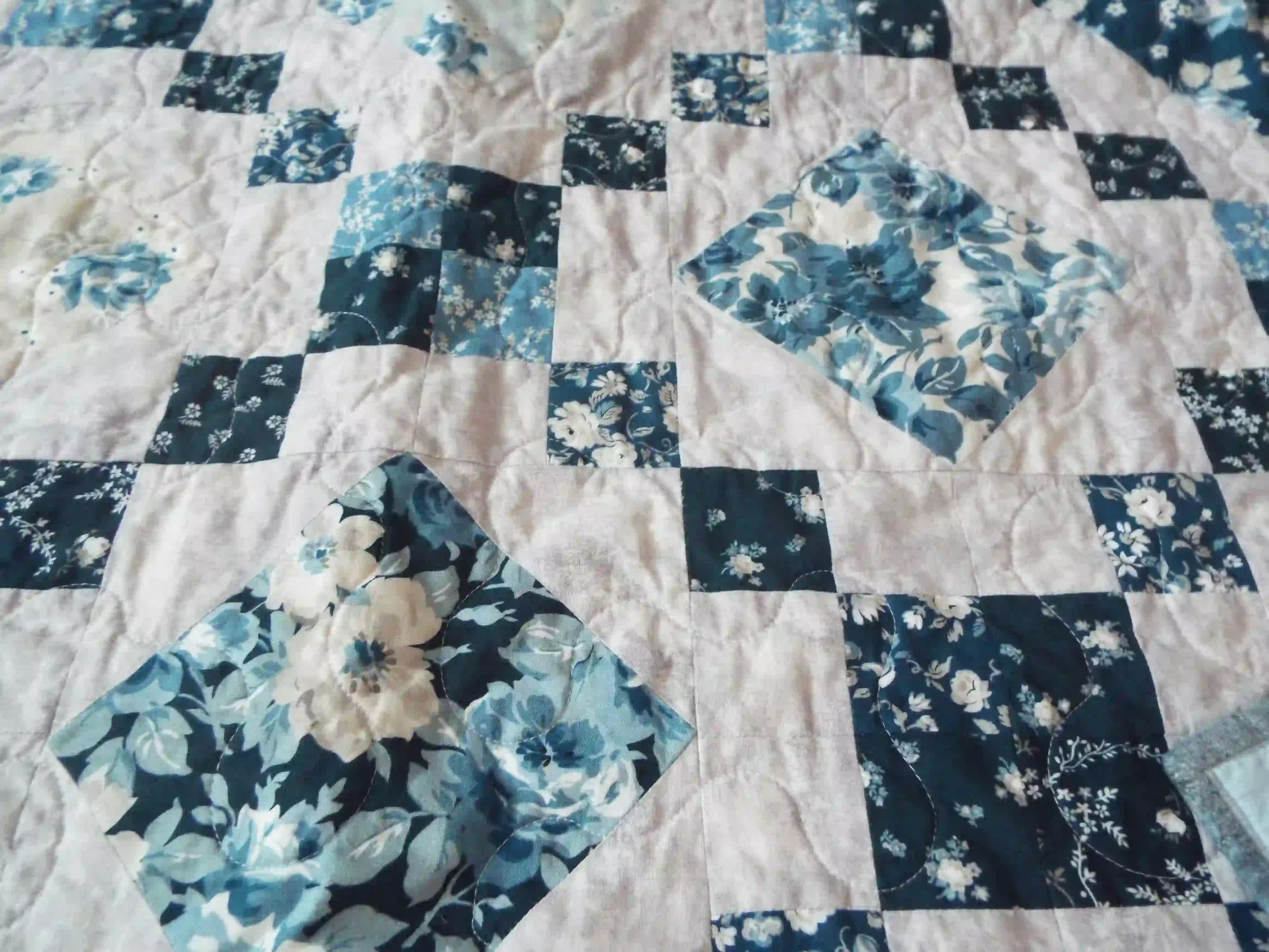 Close up of Weathered Blue lap quilt showing fabric detail and quilt stitching detail.