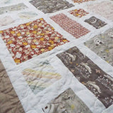 Angled lay of a handmade quilt showing closer look at fabrics used.