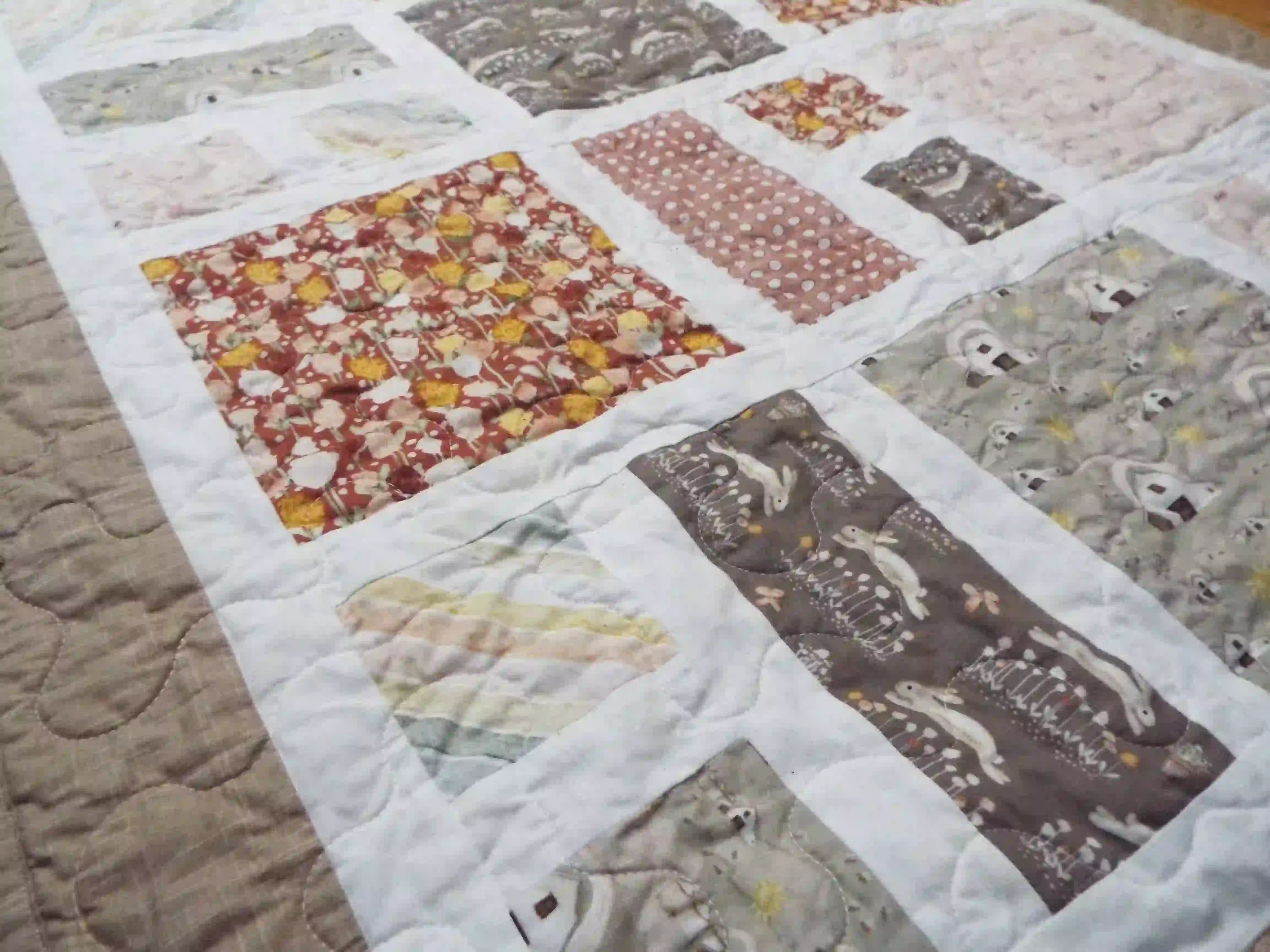 Angled lay of a handmade quilt showing closer look at fabrics used.