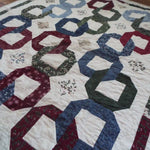 Angled lay of Winter Links Lap Quilt showing pattern.