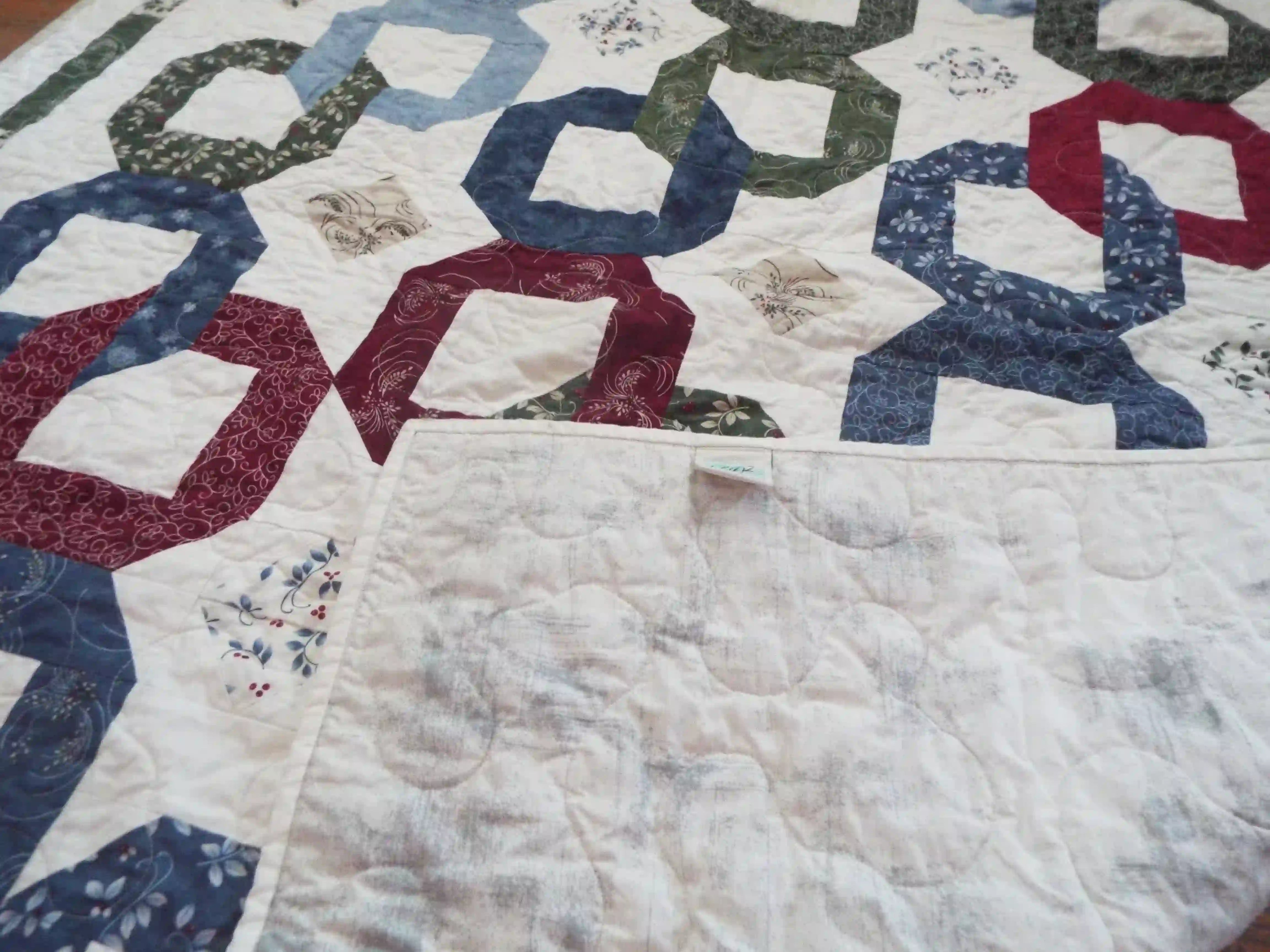 Corner flipped up for Winter Links Lap Quilt to show the backing.