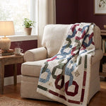 Winter Links Lap Quilt shown draped over an upholstered chair in a comfortable reading corner.