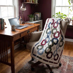 Winter Links Lap Quilt shown draped over a comfortable office chair in a home office.