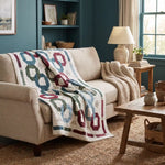 Winter Links Lap Quilt shown draped over the back of a sofa in a simply decorated living room.