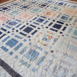 Angled lay of Woven Breeze showing closer detail of fabrics used in quilt.