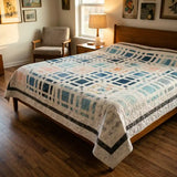 Woven Breeze queen quilt shown in a curated modern bedroom with wooden floors.