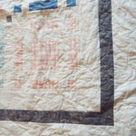 Detail of Woven Breeze queen showing binding, borders, and quilt stitching.