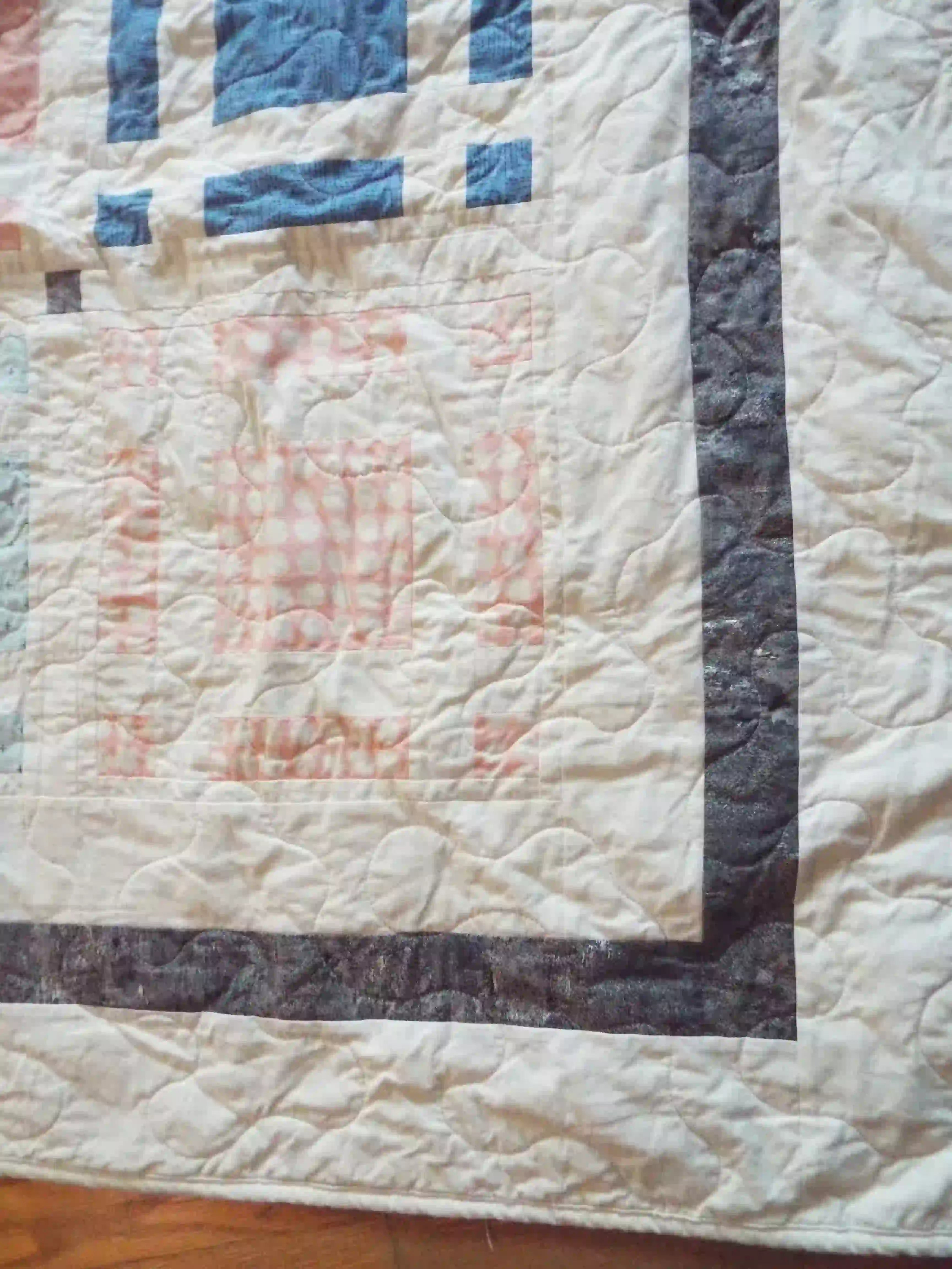 Detail of Woven Breeze queen showing binding, borders, and quilt stitching.