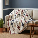 Woven Freedom lap quilt shown draped over the corner of a neutral couch