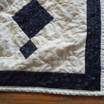 Woven Freedom lap quilt close up showing stitching and binding