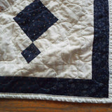Woven Freedom lap quilt close up showing stitching and binding