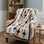 Woven Freedom lap quilt shown draped over a chair in a reading nook.