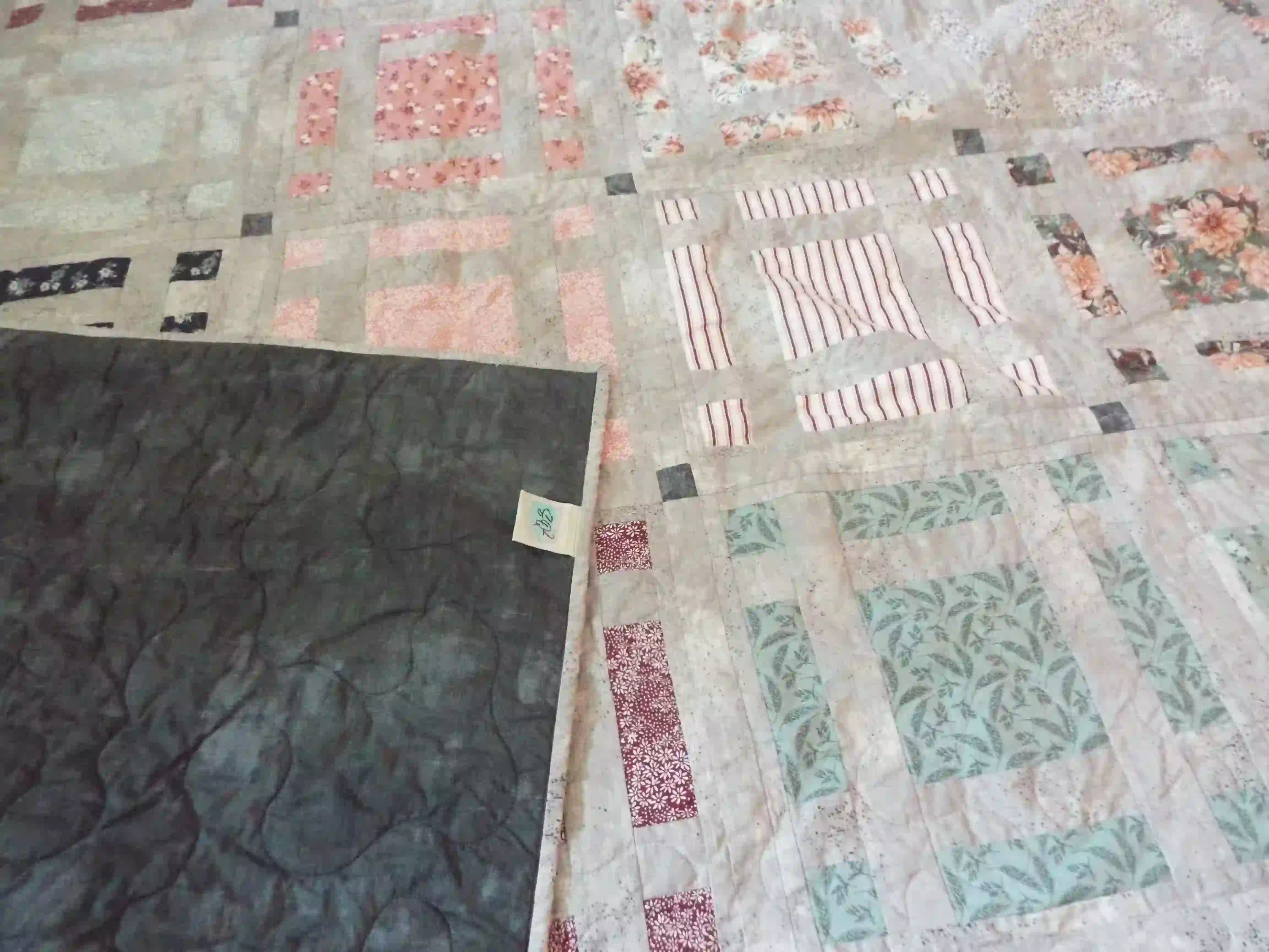 Woven Stillness queen quilt shown with corner flipped over for stitching detail and backing.